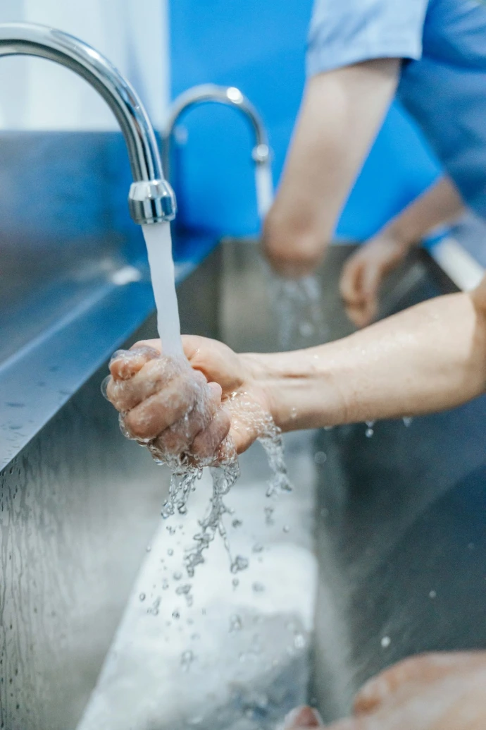 a person washing their hands in a sink